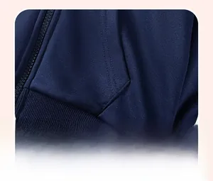 Détail du sweat à capuche bleu marine pour garçons montrant l'ourlet côtelé et le zip en résine