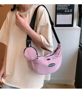 Detailed view of pink crescent nylon bag with adjustable strap and small round coin purse