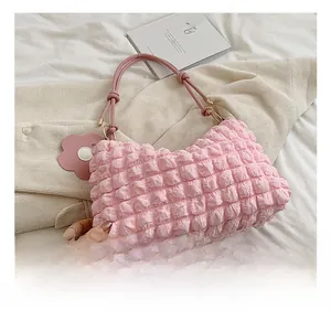 Close-up of pink popcorn textured tote bag with floral charm and metal buckles