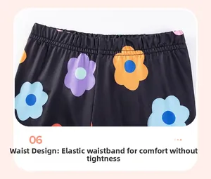 Close-up of elastic waistband on girls' black floral leggings with colorful flower prints