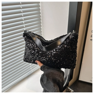 Detail einer schwarzen Pailletten-Handtasche mit Metallkette und Lederriemen-Detail