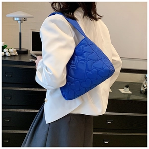 Detail der hellblauen Nylon-Einkaufstasche mit Herzsteppung an einem Modell im Büro