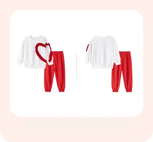 Detail view of girls long-sleeve sweatshirt and pants set with heart ruffle applique