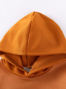 Gros plan d'un sweat-à-capuche orange pour garçons avec tissu en maille et coutures précises