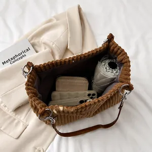 Close-up of brown corduroy tote bag showing large capacity for phone, wallet, and umbrella