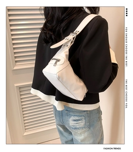 Detailed back view of a white minimalist shoulder bag on a model featuring a wide strap