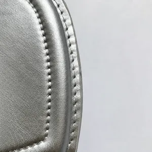 Détail du sac argenté montrant le similicuir fin et les coutures de précision