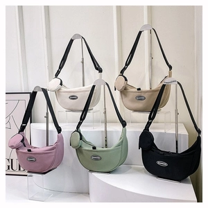 Detail of five nylon crescent crossbody bags in various colors with round coin pouches