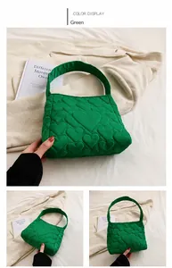 Detail of green quilted tote bag featuring heart pattern embroidery and nylon texture