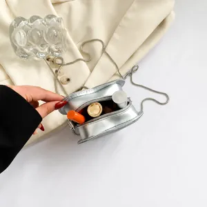 Vue détaillée du petit sac cœur argenté montrant le rangement du rouge à lèvres