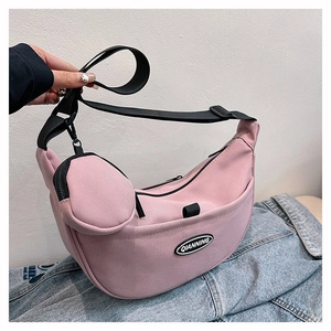 Detail of pink nylon crescent crossbody bag with adjustable strap and small round pouch
