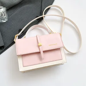 Detail of pink and beige mini crossbody bag with metal buckle and smartphone for scale