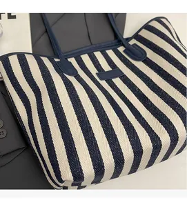 Detailweergave van de blauw-wit gestreepte draagtas met hoogwaardige blauwe lederen handvatten