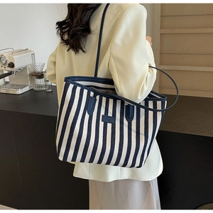Moderne gestreepte canvas shopper gestileerd tegen een minimalistisch café decor