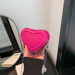 Pink heart-shaped mini quilted crossbody bag with silver chain strap and fashion logo