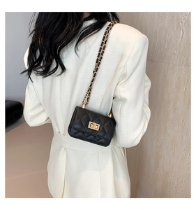 Schwarze gesteppte Minikette-Tasche getragen von einem Modell über einem Blazer