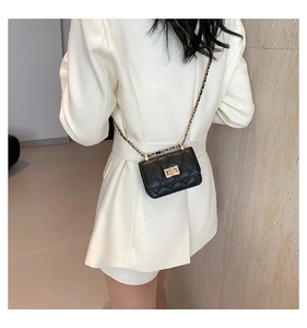 Schwarze Mini-Umhängetasche mit Steppmuster und Goldkette, getragen zum weißen Blazer