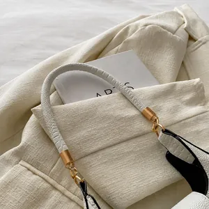 Détail de la poignée en cuir blanc gaufré avec des garnitures métalliques dorées chic