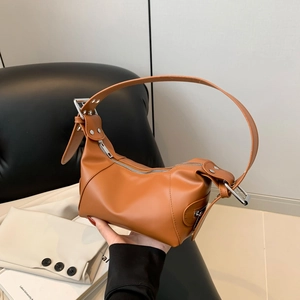 Caramel crescent hobo bag with silver studs and adjustable strap shown on shoulder