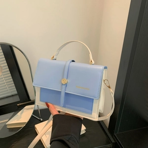 Sac à main bleu et beige en similicuir avec rabat et boucle ronde en métal doré