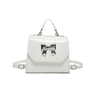 White faux leather crossbody bag with silver bow accent and adjustable shoulder strap