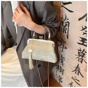 Close-up of vintage floral embroidery on cheongsam bag with golden tassel and bead clasp