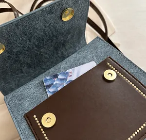 Close-up of internal storage pocket with brown leather trim and golden magnetic snap