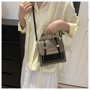 Détail du sac à bandoulière vintage marron avec clous dorés et lettrage de marque