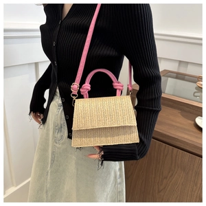 Détail du sac bandoulière en paille tissée avec poignée nouée et bandoulière en cuir rose