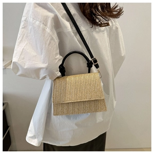 Vue détaillée du sac à main tissé beige avec motif chevron sur un mannequin