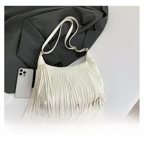 Détail du sac blanc à franges avec texture grainée et boucle métallique dorée élégante