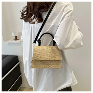 Détail du sac bandoulière en paille tressée beige avec poignée nouée noire et sangle