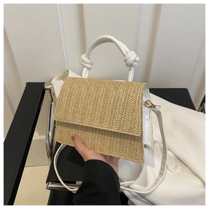 Détail du sac à main en paille tressée avec poignée blanche nouée et bandoulière