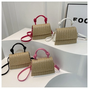 Détail de sacs bandoulière en paille tressée avec poignées nouées en plusieurs couleurs