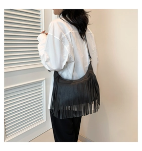 Vue détaillée du sac à franges en cuir noir avec texture grainée et style bohème chic
