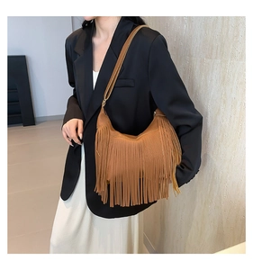 Sac à bandoulière marron avec franges de style bohème porté par un mannequin