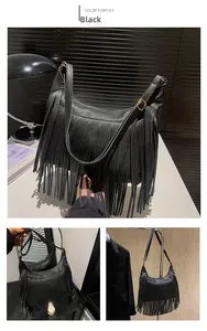 Détail d'un sac hobo en cuir grainé noir avec de longues franges et boucles dorées