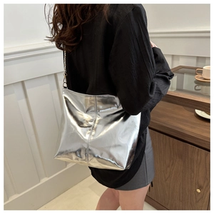 Close-up of the silver metallic tote bag featuring pleated texture and metal chain strap