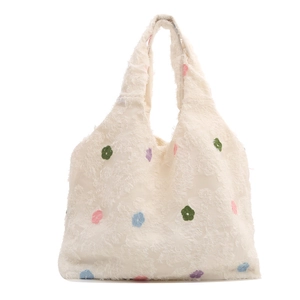 White linen tote bag with colorful floral embroidery and soft plush texture