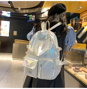 Détail d'un sac à dos holographique blanc avec plusieurs poches et sangles latérales solides