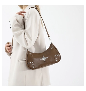 Sac bandoulière marron Y2K avec grand logo étoile en métal et rivets porté par un mannequin