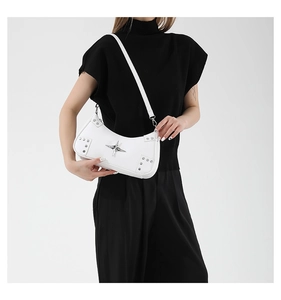 Détail d'un sac demi-lune blanc avec un grand logo étoile argenté et des rivets déco