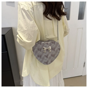 Vue détaillée arrière du sac bandoulière en forme de cœur avec texture grise et nœud