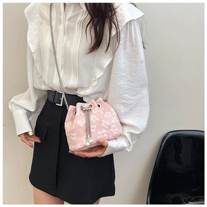 Detail view of pink floral jacquard bucket bag with pearl tassels and silver chain strap
