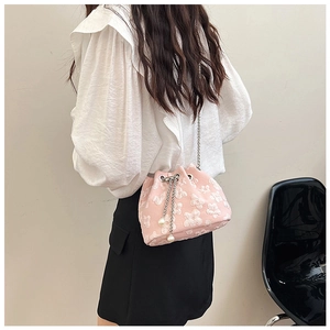 Detailed close-up of pink bucket bag with 3D floral jacquard and pearl charm decoration