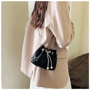 Detail of black drawstring bucket bag with floral embroidery and elegant pearl charms