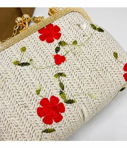 Détail du sac en paille tressée avec broderie florale et fermoir doré en métal