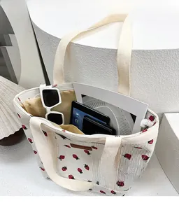 Detail view of large strawberry tote bag showing spacious interior with tablet and wallet