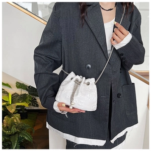 Detail of white floral jacquard bucket bag with silver chain and pearl drawstring charms