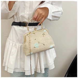 Détail de broderie florale sur sac en dentelle rétro avec poignée anneau doré